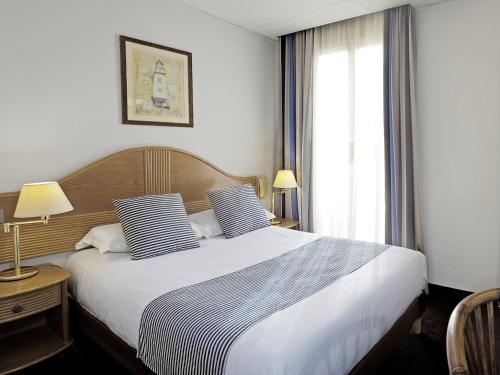 a hotel room with a bed and two lamps at Hôtel Esprit d'Azur in Nice