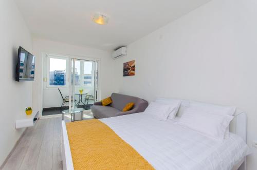 ein weißes Schlafzimmer mit einem Bett und einem Stuhl in der Unterkunft Super amazing apartments in Split