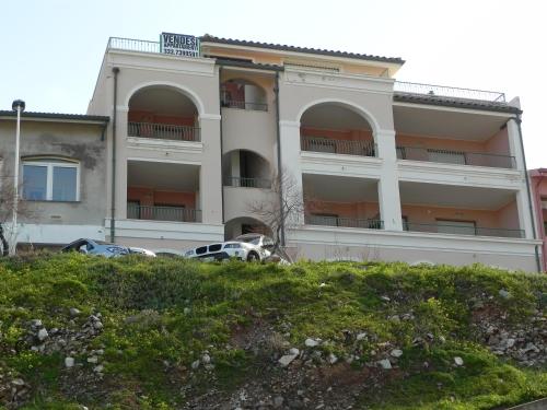 a building with cars parked in front of it at Buggerru a Mare Residence in Buggerru
