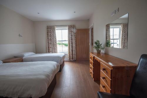 a hotel room with two beds and a mirror at Strule Cottage in Strabane