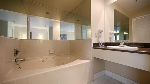 a bathroom with a tub and a sink and a mirror at Best Western Plus Inn Scotts Valley in Scotts Valley