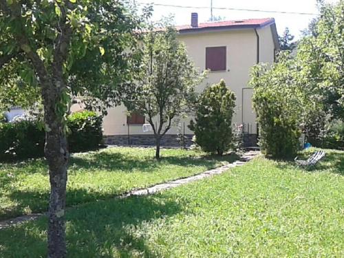 ein Haus in einem Hof mit Bäumen und Gras in der Unterkunft Belvilla by OYO Casa Via Pieve in Ponte della Venturina