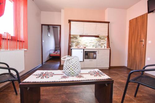 a living room with a table and a kitchen at Pokoje Gościnne Estilo in Witów