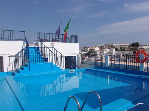 uma grande piscina com escadas e um edifício em Apartamentos Turisticos Regina em Albufeira