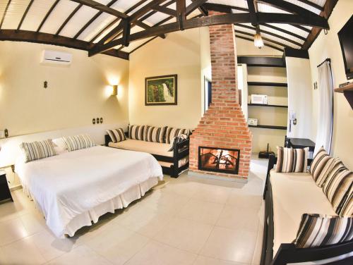 a bedroom with a bed and a fireplace at Recanto Alvorada Eco Resort in Brotas