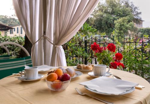 a table with cups and bowls of fruit on it at Hotel Verdemare in Marina di Pietrasanta