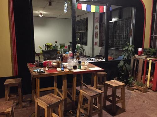 フアイサーイ郡にあるLittle Hostelのテーブルとスツールが備わる部屋