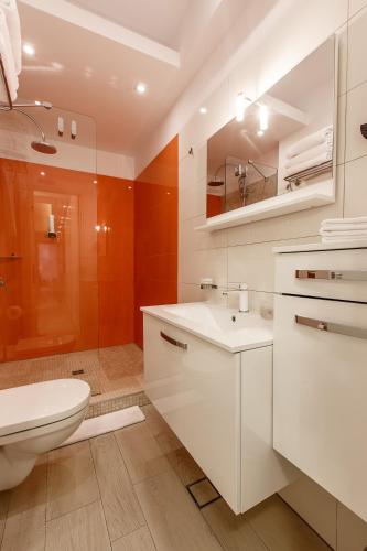 a white bathroom with a toilet and a sink at Mava Apartamente in Constanţa