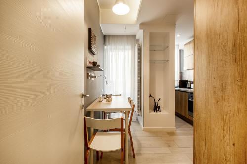 a small kitchen and dining room with a table and chairs at Mava Apartamente in Constanţa