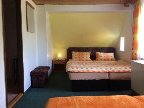 - une petite chambre avec un lit et une table de nuit dans l'établissement penzion Podlesí, à Kořenov