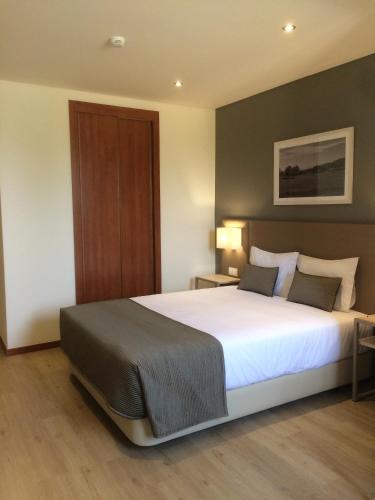 a bedroom with a large white bed in a room at Hotel Ponte Sor in Ponte de Sor