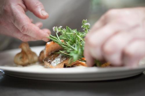 a person eating a plate of food on a table at Familiengut Hotel Burgstaller in Döbriach