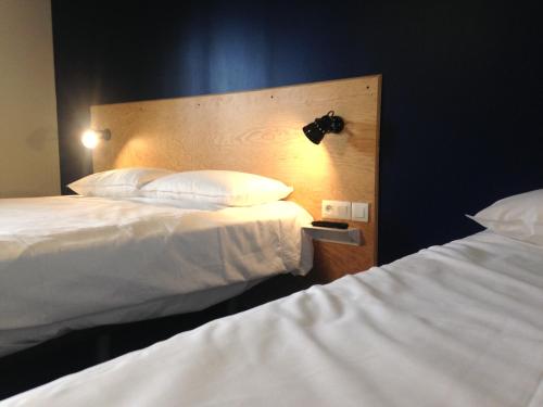 a hotel room with two beds and a head board at Eklo Hotels Lille in Lille