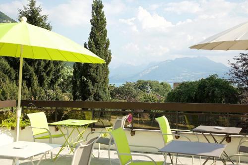 a patio area with chairs, tables, and umbrellas at Centre Jean XXIII in Annecy
