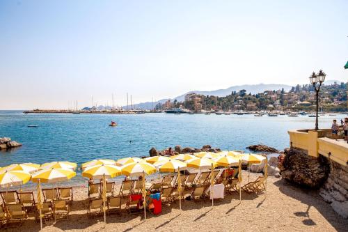 a group of chairs and umbrellas on a beach at Albergo La Piazzetta in Rapallo