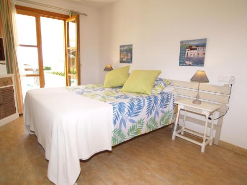 a white bedroom with a bed and a table at Apartment Son Durí seawiews 13 in Sa Ràpita