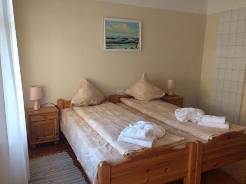 a bedroom with a bed with towels on it at Viesu Nams Mežu 13 in Ventspils