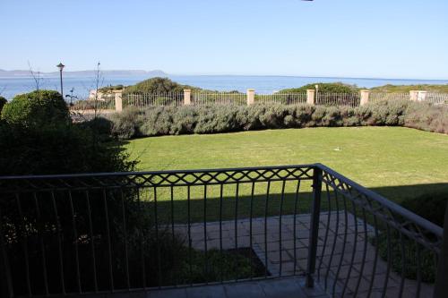 a view of a large grassy yard with the ocean at On The Cliff Guest House in Hermanus