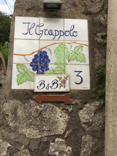 a sign on the side of a stone wall at B&B Il Grappolo in Anacapri