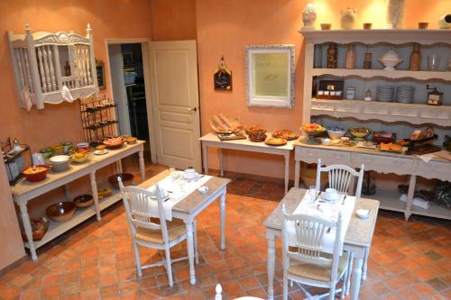 una habitación con mesas, sillas y comida a la vista en Hotel du Poète, en Fontaine-de-Vaucluse