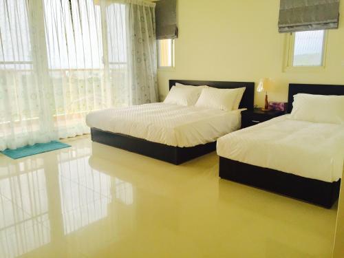 a bedroom with two beds and a window at Tamowan in Donghe
