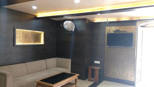 a living room with a couch and a tv at City Hotel in Allahābād