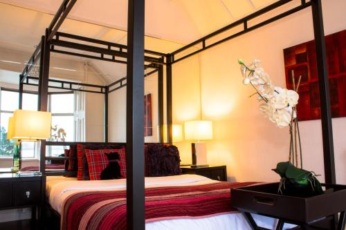 a bedroom with a bed with a four poster bed frame at Haylie Hotel in Largs