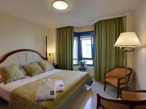 a hotel room with a bed with two towels on it at Hotel Golf Campoamor in Dehesa de Campoamor