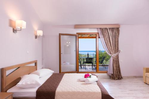 a bedroom with a bed and a view of the ocean at Kapsogeorgis Rooms in Koinyra