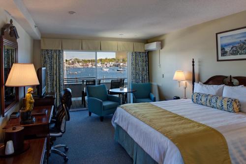 a hotel room with a bed and a view of the water at Browns Wharf Inn in Boothbay Harbor