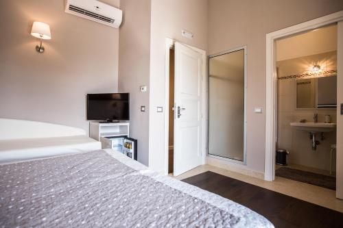 a bedroom with a bed and a tv and a mirror at Il Fortino in Celano