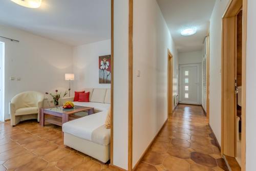 a living room with a white couch and a table at Apartments Tamar in Jelsa