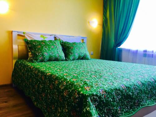 ドミトロフにあるАпартаменты на Школьнойのベッドルーム1室(緑色のベッド1台、窓付)