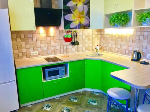 ドミトロフにあるАпартаменты на Школьнойの緑豊かなキッチン(シンク、電子レンジ付)
