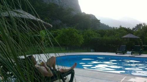 a woman laying in a hammock next to a swimming pool at Portalimo Lodge Hotel - Adult Only +12 in Cıralı