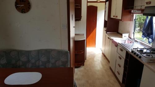 a small kitchen with a stove and a sink at Dom Pod Dębami in Wola Kopcowa