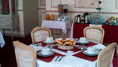 une table à manger avec un tissu de table rouge et blanc dans l'établissement Grand Hotel de l'étoile, à Courtenay