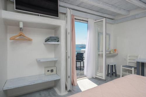 a white bedroom with a view of the ocean at Naxian Althea in Agia Anna Naxos