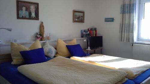 インメンシュタット・イム・アルゴイにあるHaus Bergpanoramaのベッドルーム1室(青と黄色の枕が備わるベッド1台付)