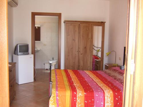 a bedroom with a bed with a colorful blanket at Agriturismo Tattarini in Fonteblanda