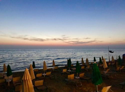 a group of chairs and umbrellas on a beach at Casa Vacanze Il Cenito in Castellabate