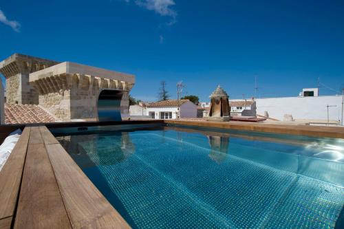 a swimming pool in a villa with blue water at Sindic Hotel - Adults Only in Mahón
