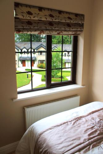 a bedroom window with a view of a yard at Garden View Self Catering Lough Rynn in Mohill