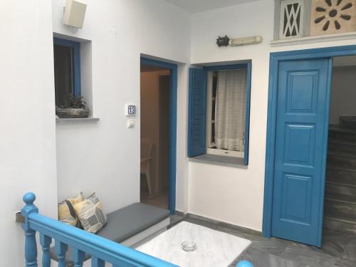 a room with a blue door and a window at Manto Apartments in Tinos Town