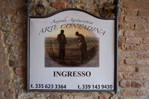 a sign hanging on a brick wall at Agriturismo Arte Contadina in Fiorenzuola dʼArda