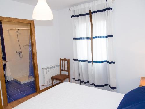 a bedroom with a bed and a shower and a mirror at Pension Rustica Casa Do relojero in Zas