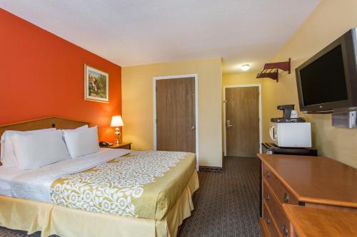 a hotel room with a bed and a flat screen tv at Days Inn by Wyndham Chincoteague Island in Chincoteague