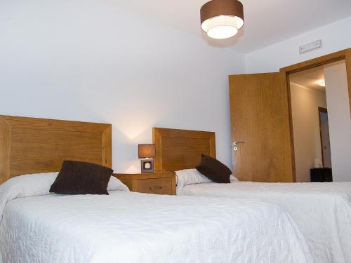 a bedroom with two beds with white sheets at Pension Rustica Casa Do relojero in Zas