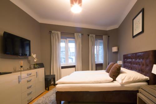 a bedroom with a bed with a television and a dresser at Auberge De L'Our in Vianden