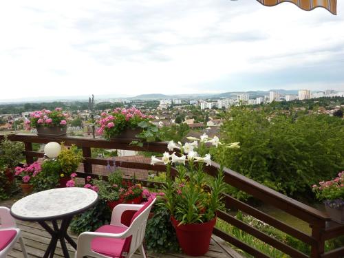 a balcony with a table and chairs and flowers at Les Terrasses de Bellemoure Cébazat in Cébazat